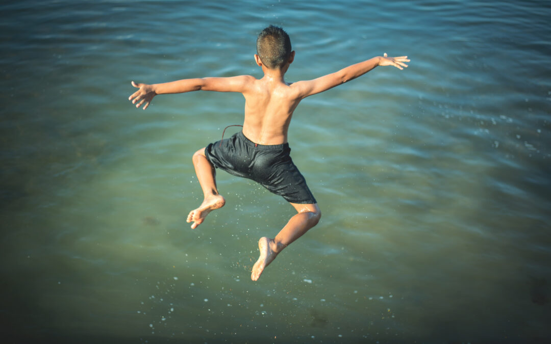 Active Boy Jumping Into The Water