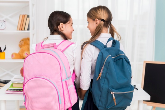 schoolgirls-with-backpacks-looking-each-other_23-2148224831